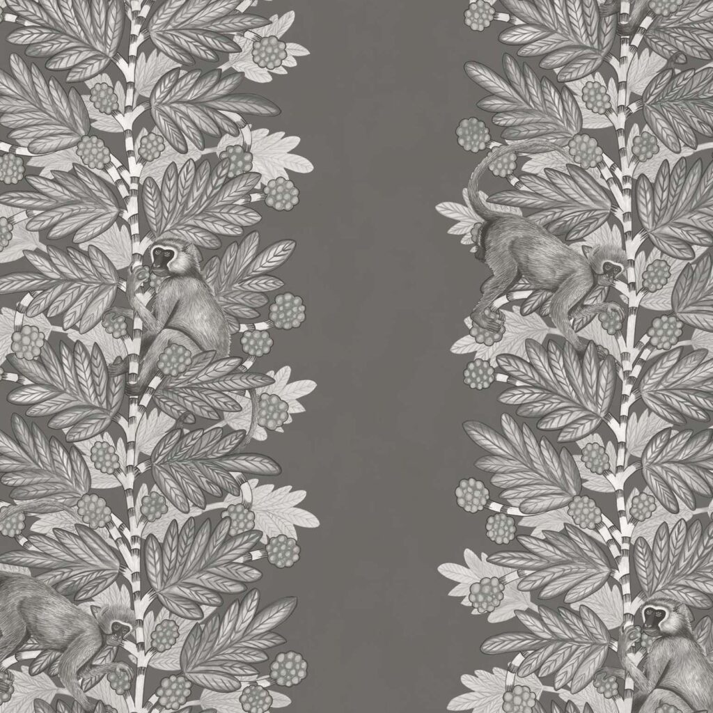 Grijstinten behangpatroon van Cole and Son met apen tussen acaciabladeren en bessen.