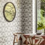 Woonkamer met Ardmore Cameos behang van Cole and Son, voorzien van dierensilhouetten in ovale patronen.