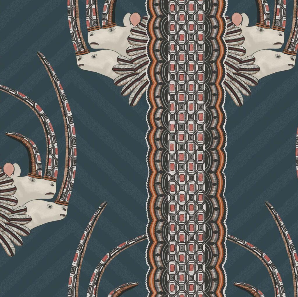 Decoratief behangpatroon van Cole and Son Ardmore Jabu 109/3015 met gestileerde antilopekoppen en geometrische motieven op een donkerblauwe achtergrond.