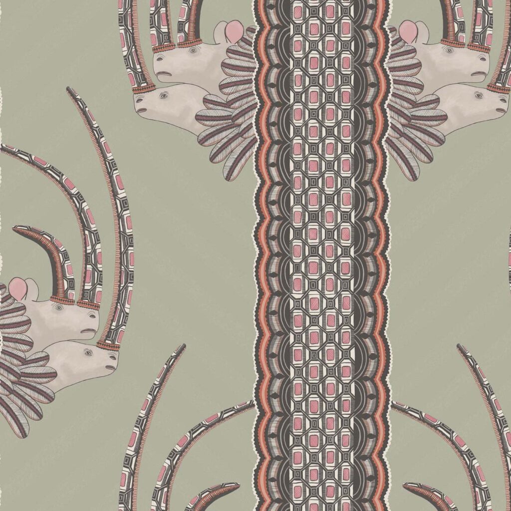 Decoratief behangontwerp van Cole and Son met gestileerde antilopekoppen en symmetrische etnische patronen in roze, grijs en zwart op een groene achtergrond.