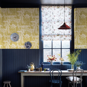 Sfeervolle eetkamer met Cole and Son Cow Parsley behang in okergeel, vintage meubels en bloemrijke accenten.
