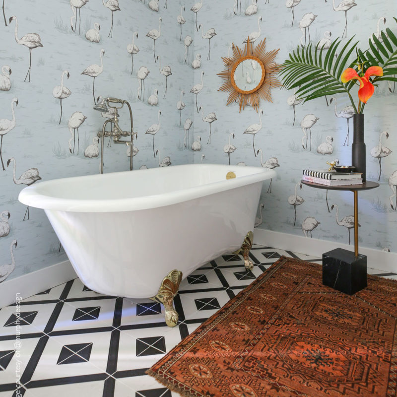 Stijlvolle badkamer met vrijstaand bad, Cole and Son flamingenbehang, en chique vintage accenten.