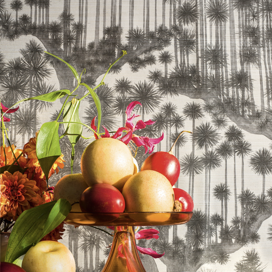Stilleven met exotisch fruit en bloemen voor een Cole & Son Japanese Woods Grasscloth behang met palmboommotief.
