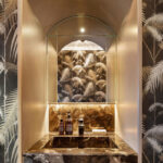 Luxe toiletruimte met marmeren wastafel en Cole and Son Palm Jungle-behang in zwart en wit.