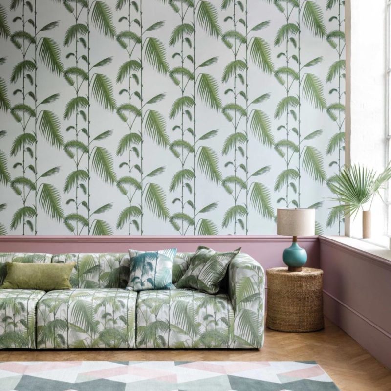 Woonkamer met een Cole and Son Palm Leaves-behang en bijpassende bank met palmbladmotief.