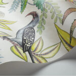 Gedetailleerd Savuti-behang uit de Ardmore-collectie van Cole and Son met een exotische vogel tussen kleurrijke bladeren.