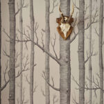 Behang met een zwart-wit boompatroon uit de Cole and Son Woods Icons-collectie, met een schedel met hoorns aan de muur.