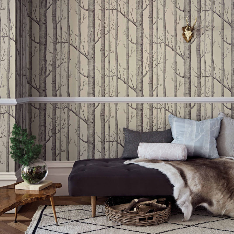 Sfeervolle woonkamer met Cole and Son Woods Icons behang met boompatroon en stijlvolle, rustieke decoratie.