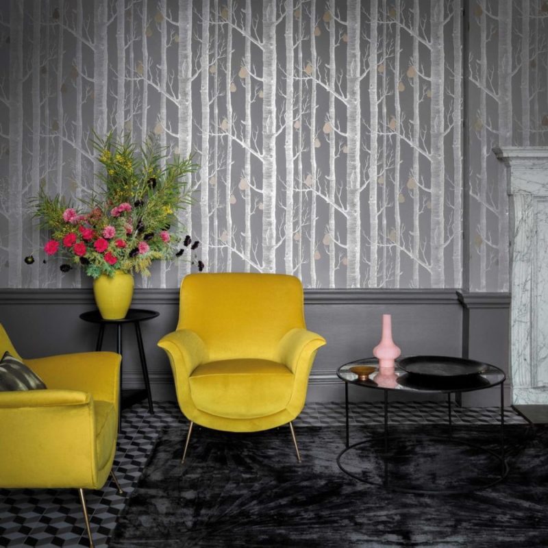 Interieur met gele fauteuils, bloemenvaas en Cole and Son Woods and Pears-behang met boom- en perenmotief.