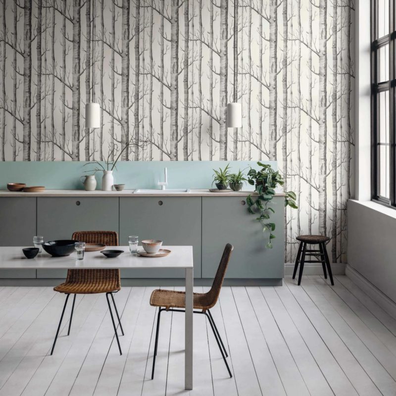 Moderne keuken met lichtgroene kasten, een witte eettafel en een opvallend Cole and Son 'Woods' boompatroonbehang.