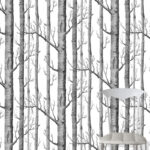 Behang met zwart-wit boomstamdesign uit de Cole and Son Woods-collectie met een witte stoel op de voorgrond.