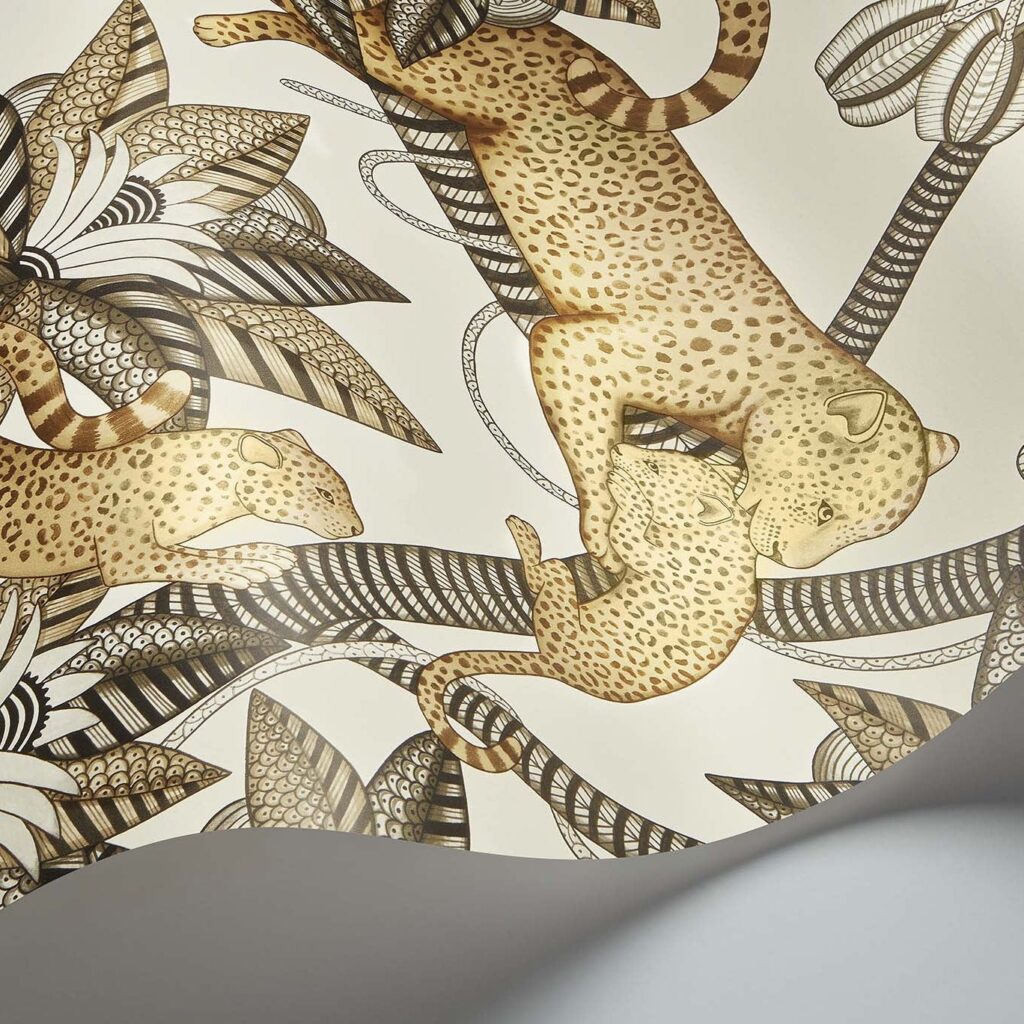 Detail van het Cole and Son Ardmore Jabula Satara behang met illustraties van luipaarden en gestileerde tropische bladeren in bruin- en goudtinten.