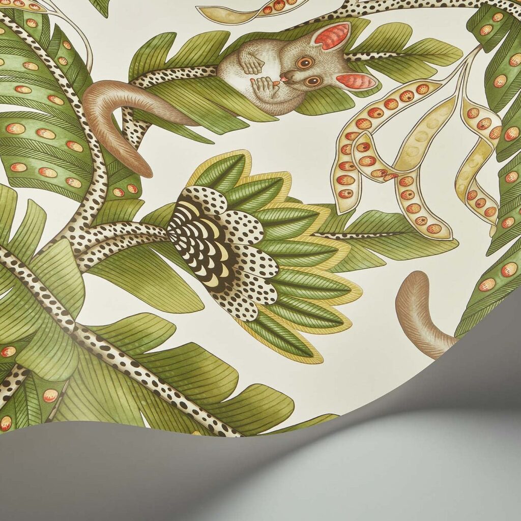 Detail van het Cole and Son Ardmore Jabula behang met een bush baby tussen groene bladeren en decoratieve patronen.