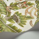Detail van het Cole and Son Ardmore Jabula behang met een bush baby tussen groene bladeren en decoratieve patronen.