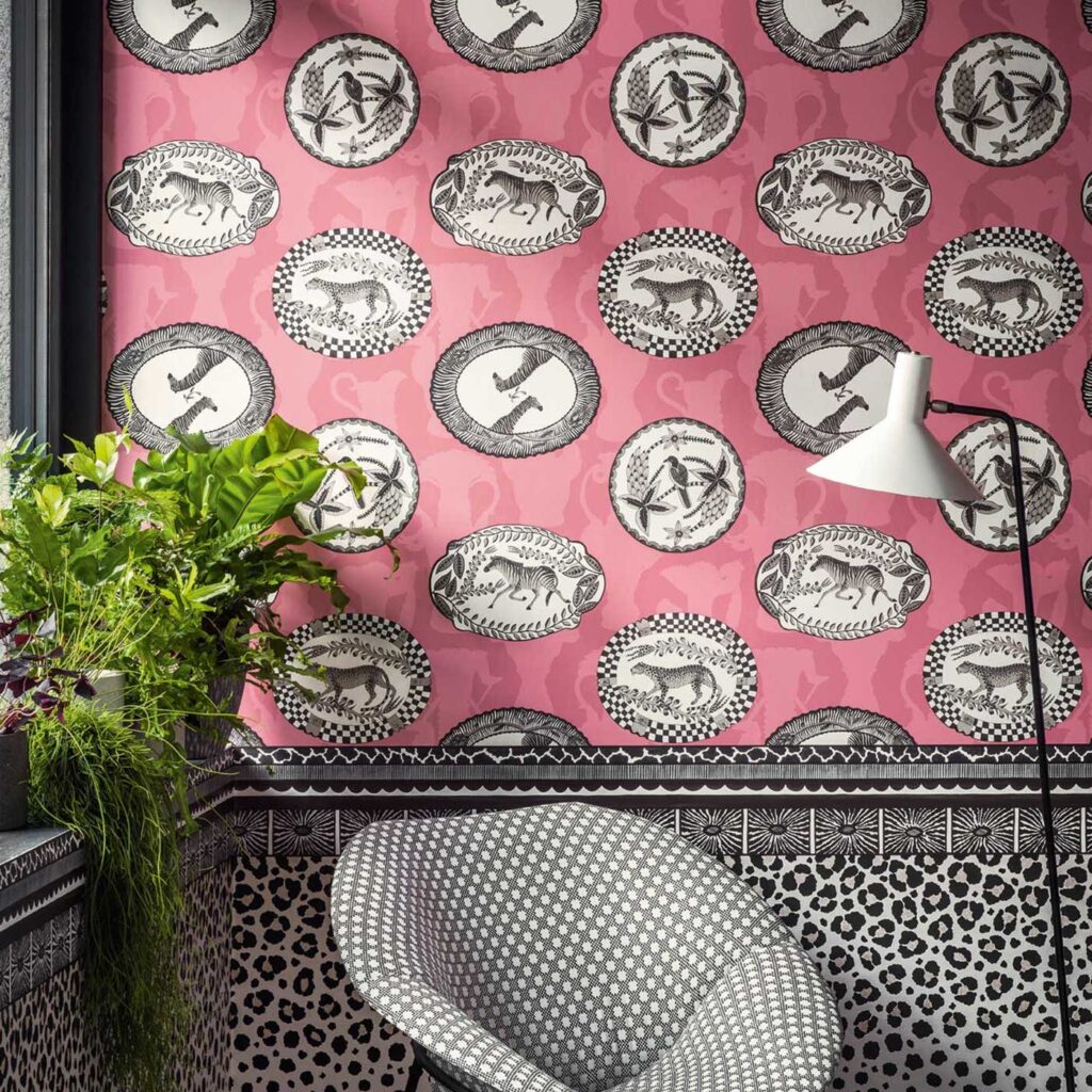 Roze behang Cole and Son Ardmore Matrinah 109/4023 met zwart-witte dierillustraties in ovale kaders.