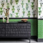 Zwarte houten kast tegen een muur met Cole and Son Ardmore Narina 109/10045 behang met groene exotische vaaspatronen.