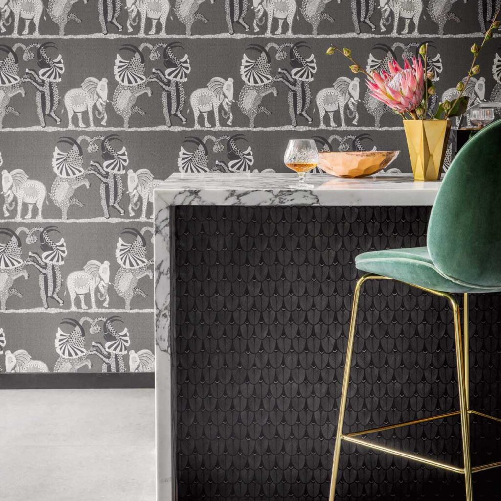 Interieur met Cole & Son Ardmore Narina behang met dierenmotief, een marmeren bar en een groene fluwelen barkruk.