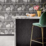 Interieur met Cole & Son Ardmore Narina behang met dierenmotief, een marmeren bar en een groene fluwelen barkruk.