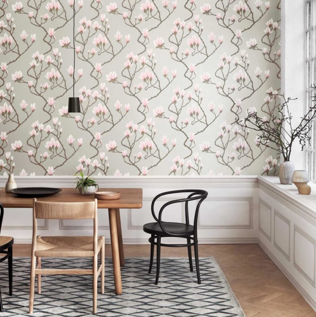 Eetkamer met Magnolia 72/3010 behang uit de Cole and Son Contemporary Collection, met roze bloesemtakken op een lichtgrijze achtergrond.