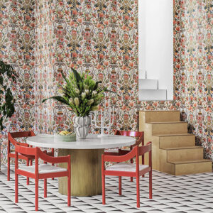 Kleurrijke eetkamer met Cole and Son Ardmore Jabula 119/10043 Protea Garden-behang, rode stoelen en een ronde tafel met bloemenvaas.
