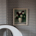 Vaas met bloemen aan de muur met Cole and Son Hicks Hexagon behang op de achtergrond.