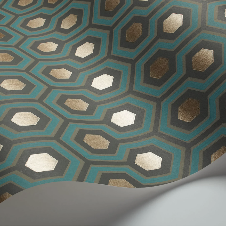 Close-up van het Cole and Son Hicks Hexagon behang met een geometrisch patroon in goud, turquoise en zwart.