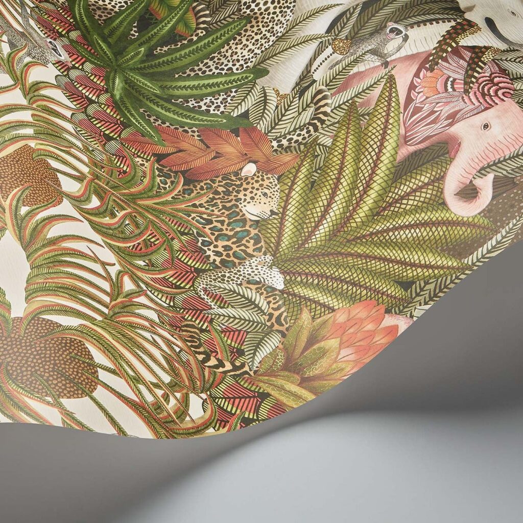 Detail van het Cole & Son Ardmore Jabula behang met kleurrijke junglebladeren, luipaarden en een roze olifant.