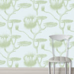 Witte stoel voor lichtblauw behang met groen leliepatroon van Cole and Son.