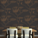 Eetkamerinterieur met Cole and Son behang 'Lily' in donkere tinten en een houten eettafel met lichte stoelen.