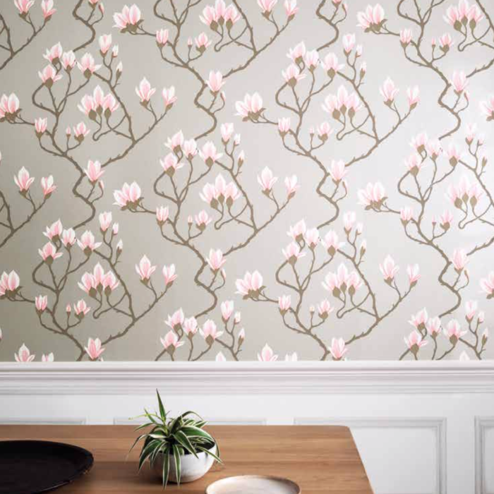 Behang met een patroon van roze magnoliabloemen uit de Magnolia Contemporary-collectie van Cole and Son tegen een beige achtergrond.