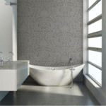 Moderne badkamer met vrijstaand bad en grijs Cole and Son Malabar behang met sierlijk patroon.