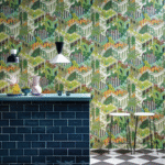 Interieur met kleurrijk Cole & Son Miami behang, donkerblauwe tegelbar en moderne barkrukken.