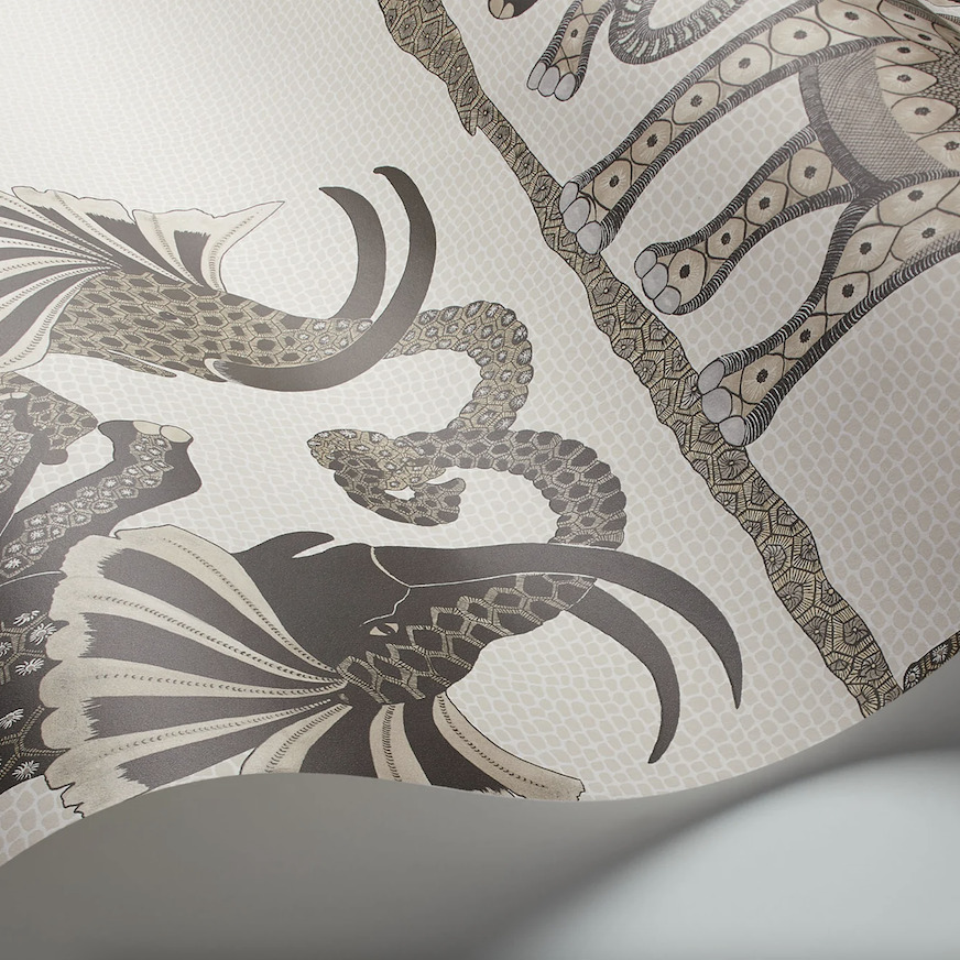 Behang uit de Ardmore-collectie van Cole and Son met gedetailleerde illustraties van dansende Afrikaanse dieren in aardetinten.