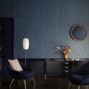 Donkerblauwe kamer met Cole and Son Feather Fan behang, moderne meubels en een gouden vaas met bloemen.
