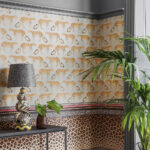 Interieurhoek met Cole and Son Leopard Walk behang, een tropische plant en een decoratieve lamp op een tafel.