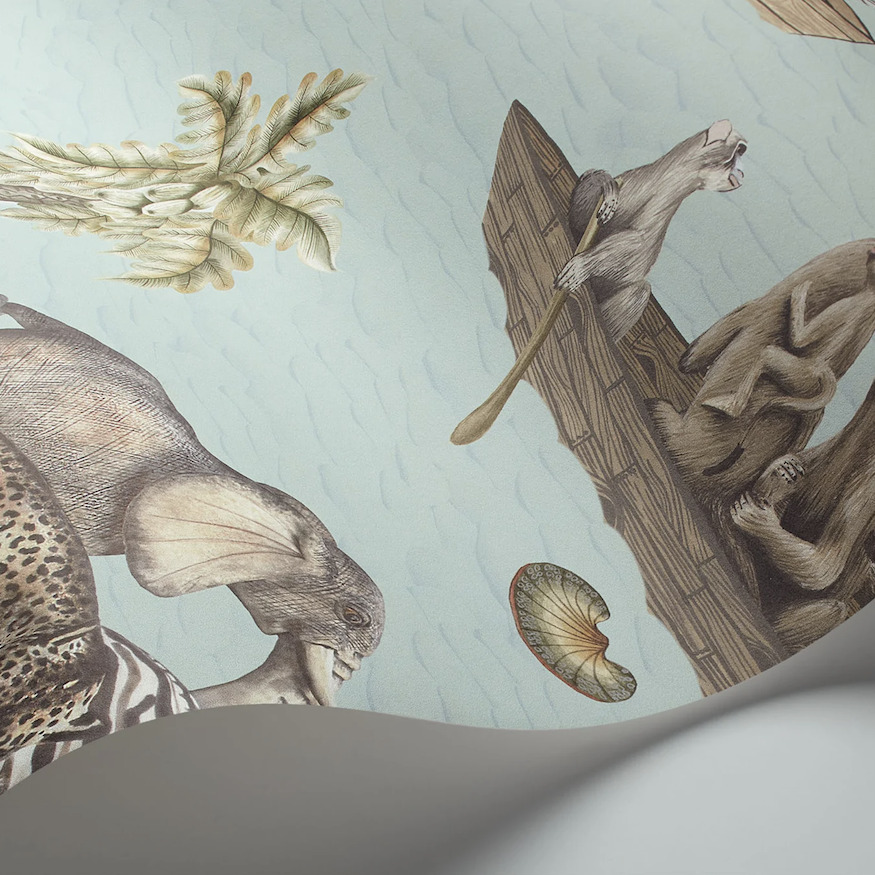 Behang uit de Cole and Son Sambezi Ardmore collectie met illustraties van dieren, waaronder een olifant, apen in een kano en tropische planten op een lichtblauwe achtergrond.