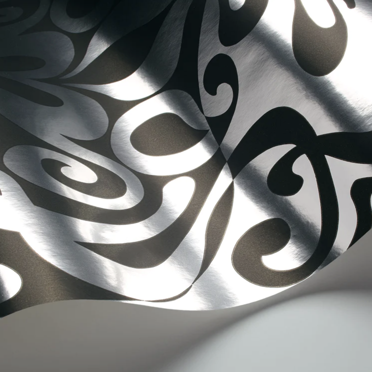 Detail van het Cole & Son Woodstock behang in zwart met glanzend zilveren krulpatroon.
