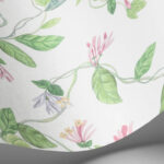 Detail van het Cole & Son Flora 124/3015 behang met sierlijke bloemen en groene bladeren op een lichte achtergrond.