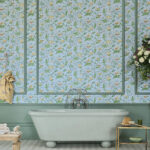 Klassieke badkamer met een vrijstaand bad en Cole & Son Hummingbirds-behang met bloemen en kolibries op een lichtblauwe achtergrond.