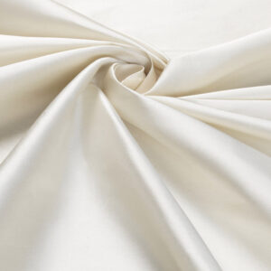 Detailopname van een glanzende, ivoorwitte zijden stof uit de Cole & Son Colour Box-collectie.