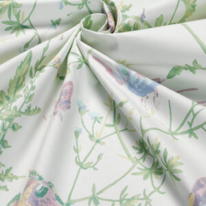 Detail van Cole & Son-stof ‘Hummingbirds’ met een pastelkleurig patroon van kolibries en groene planten op katoenen doek.