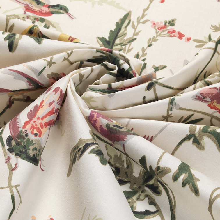 Detail van de Cole & Son-stof Hummingbirds in katoen met een bloem- en kolibriepatroon op licht achtergrond.