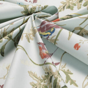 Gedetailleerde close-up van de Cole & Son katoenstof 'Hummingbirds' met een patroon van kleurrijke kolibries en bladeren op een lichtgroene achtergrond.