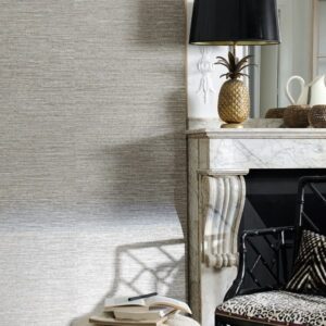 Stijlvol interieur met een marmeren schouw, zwarte lamp met gouden ananasvoet, en een zwarte stoel met dierenprintkussen.