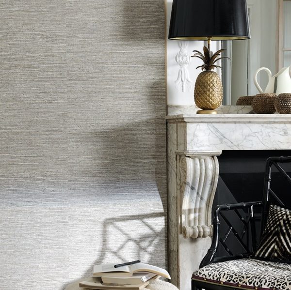 Stijlvol interieur met een marmeren schouw, zwarte lamp met gouden ananasvoet, en een zwarte stoel met dierenprintkussen.