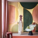 Modern interieur met kleurrijk geometrisch behang uit de collectie ‘Éclats Cosmiques’ van Véronique de Soultrait, met designmeubels en sculpturale decoratie.