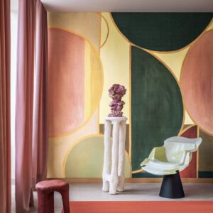 Modern interieur met kleurrijk geometrisch behang uit de collectie ‘Éclats Cosmiques’ van Véronique de Soultrait, met designmeubels en sculpturale decoratie.