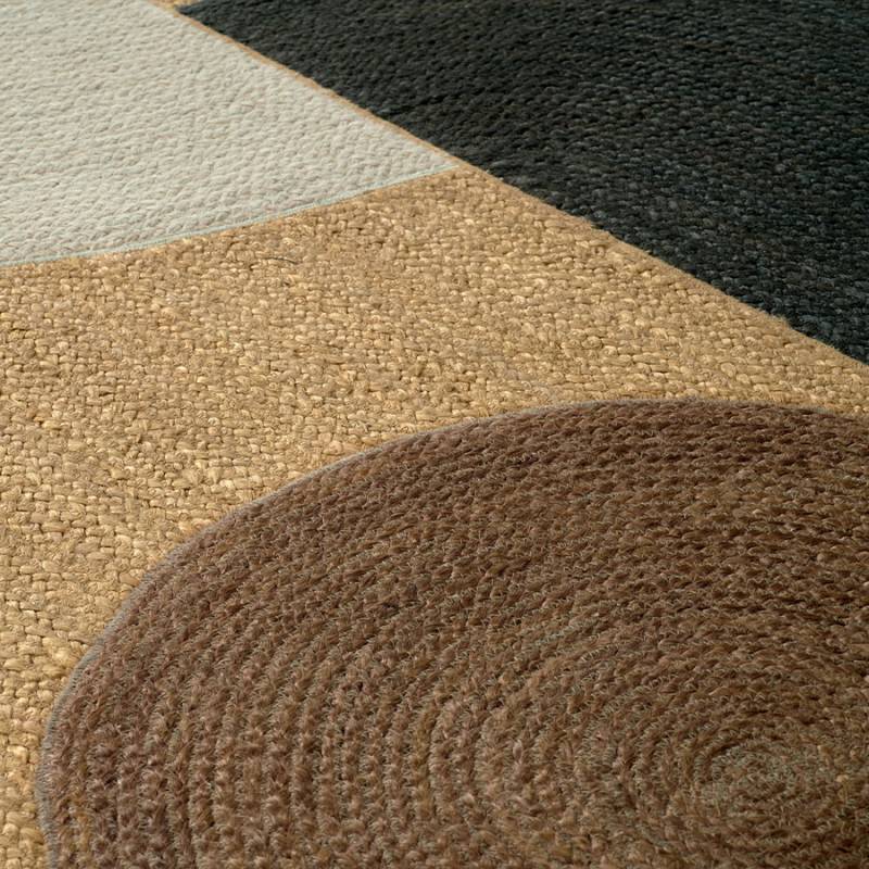 Detailopname van het Elitis Acapulco vloerkleed met geweven texturen en geometrische kleurvlakken in bruin, beige, zwart en crème.
