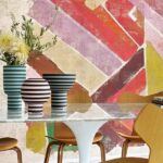 Moderne eethoek met houten stoelen, een marmeren tafel en gestreepte vazen voor een kleurrijk Elitis Allegorie RM 256 muurdesign.