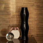 Zwarte vaas en decoratieve objecten voor een glanzend Elitis Anguille VP 952 91 metallic behang.